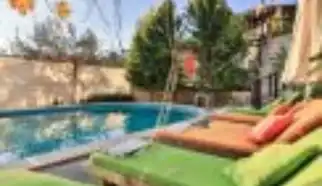 Kalkan İslamlar Köyünde konumlanan doğa manzaralı korunaklı havuza sahip Kiralik Tatil Villası Defne dört yatak odalı